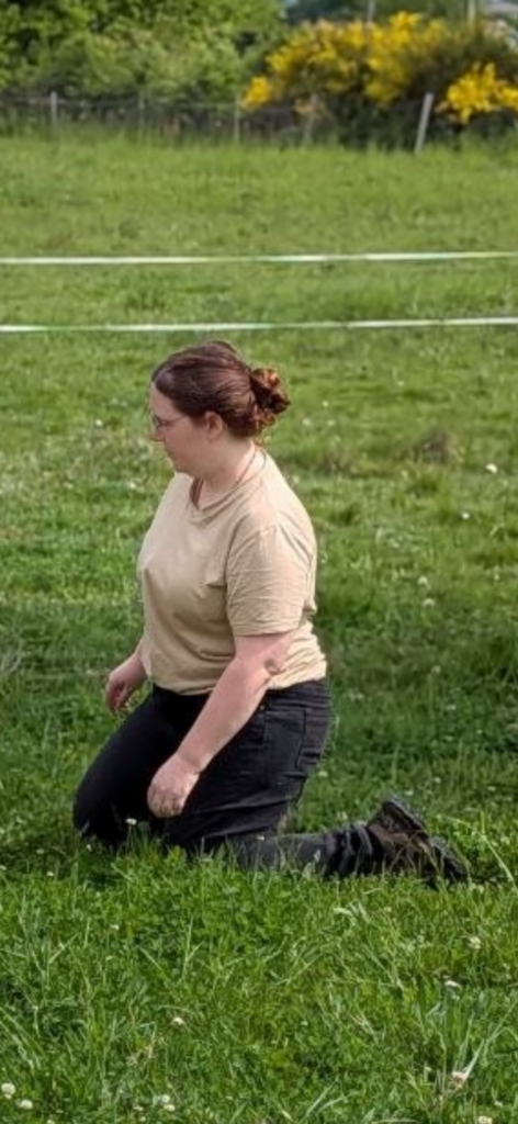 Emy, praticienne en communication animale, assise dans l’herbe